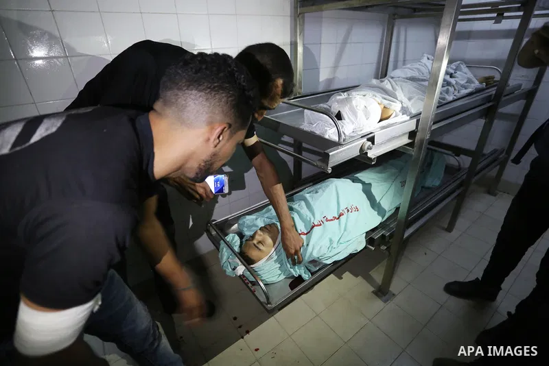 Palestinians mourn over bodies of two Palestinians who were shot dead by Israeli forces during clashes in tents protest where Palestinians demand the right to return to their homeland at the Israel-Gaza border, in a hosp...