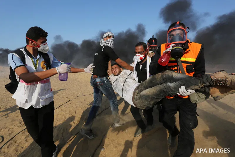 Palestinian protesters gather during clashes with Israeli troops in tents protest where Palestinians demand the right to return to their homeland at the Israel-Gaza border, in Khan Younis in the southern Gaza Strip on Se...