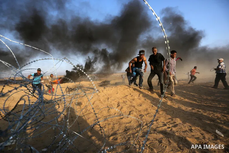 Palestinian protesters gather during clashes with Israeli troops in tents protest where Palestinians demand the right to return to their homeland at the Israel-Gaza border, in Khan Younis in the southern Gaza Strip on Se...