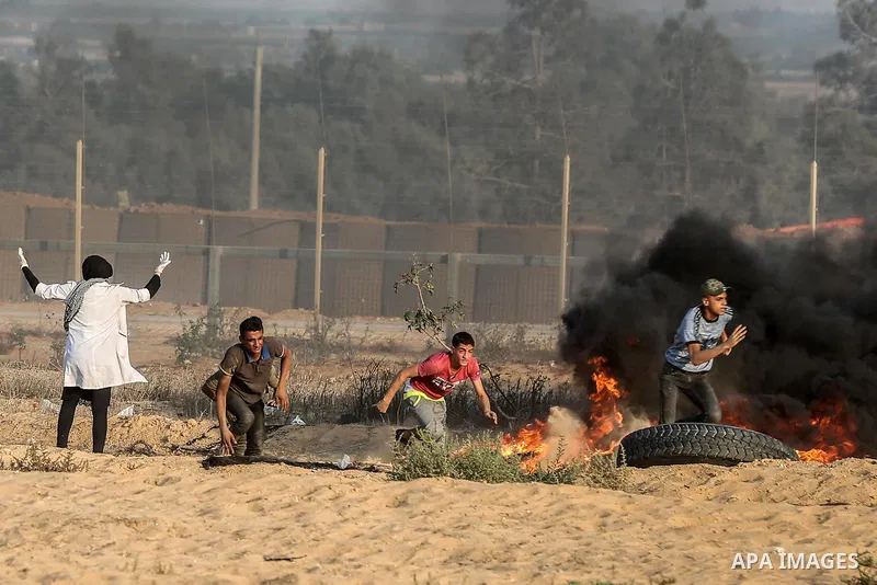 Palestinian protesters gather during clashes with Israeli troops in tents protest where Palestinians demand the right to return to their homeland at the Israel-Gaza border, in Rafah in the southern Gaza Strip on Septembe...