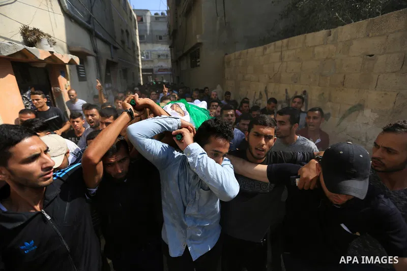 Mourners carry the body of Palestinian Mohammed Shakhsa, 24, who was shot dead by Israeli forces during clashes in tents protest where Palestinians demand the right to return to their homeland at the Israel-Gaza border,...
