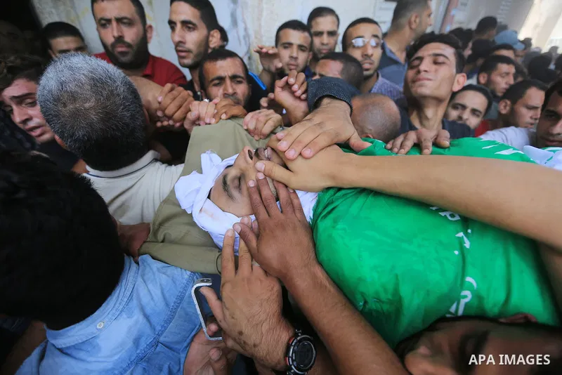 Mourners carry the body of Palestinian Mohammed Shakhsa, 24, who was shot dead by Israeli forces during clashes in tents protest where Palestinians demand the right to return to their homeland at the Israel-Gaza border,...