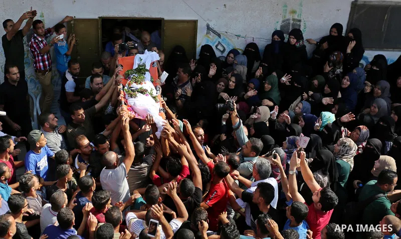Mourners carry the body of Palestinian boy Nasser Mosabih, 12, who was shot dead by Israeli forces during clashes in tents protest where Palestinians demand the right to return to their homeland at the Israel-Gaza border...