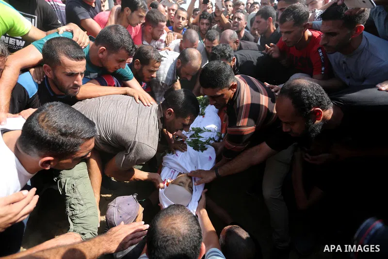 Mourners bury the body of Palestinian boy Nasser Mosabih, 12, who was shot dead by Israeli forces during clashes in tents protest where Palestinians demand the right to return to their homeland at the Israel-Gaza border,...