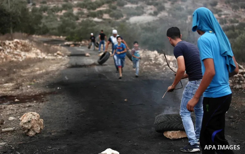 Palestinian protesters burn tires during clashes with Israeli troops against Israel's Nation State Law, and Israel's plan to demolish the Khan al-Ahmar village in the village of Kfar Qaddum, near the West Bank city of Na...