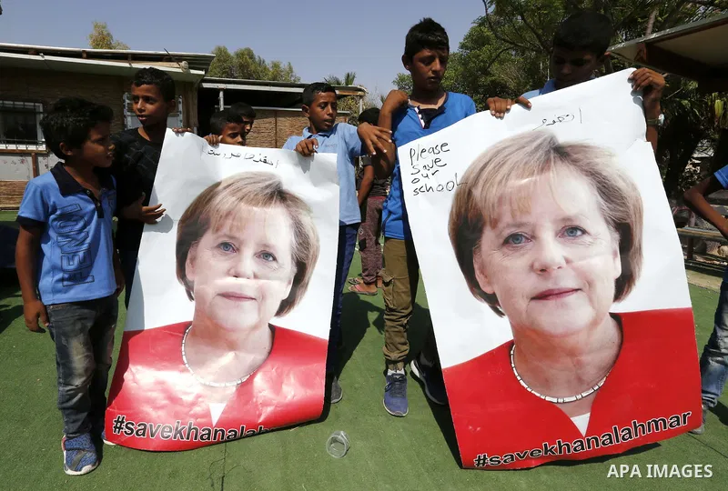 Palestinian students hold posters of German Chancellor Angela Merkel before her scheduled visit to Israel tomorrow, at the Palestinian Bedouin village of Khan al-Ahmar which Israel plan to demolish, in the occupied West...