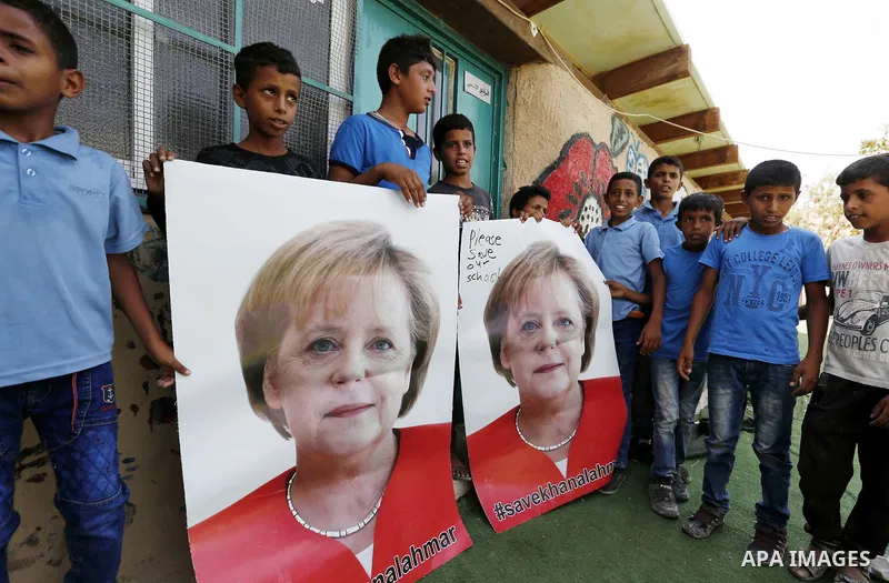 Palestinian students hold posters of German Chancellor Angela Merkel before her scheduled visit to Israel tomorrow, at the Palestinian Bedouin village of Khan al-Ahmar which Israel plan to demolish, in the occupied West...