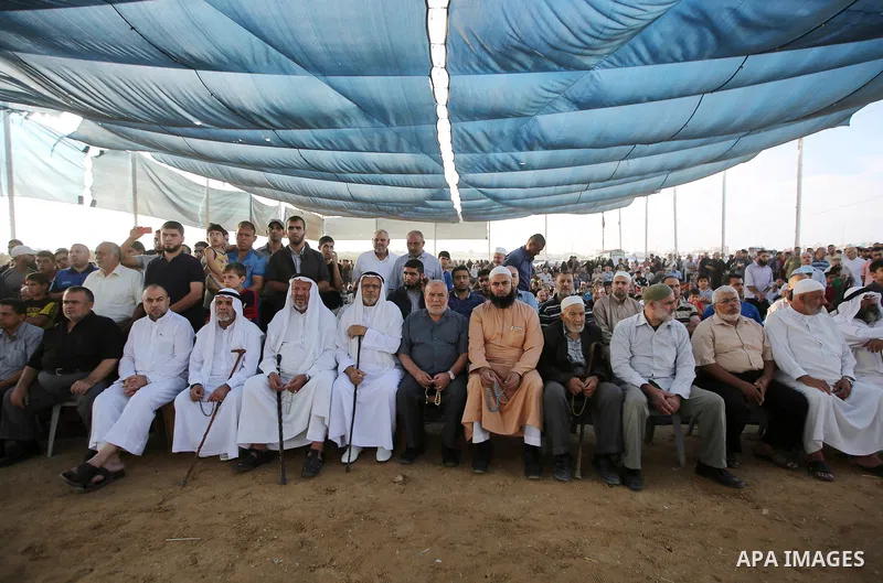Palestinians watch the speech of newly elected leader of Islamic Jihad movement, Ziad al-Nakhalah, on a large screen in tents protest where Palestinians demand the right to return to their homeland at the Israel-Gaza bor...