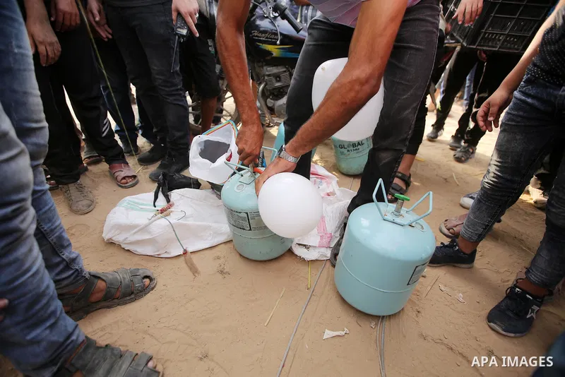 A Palestinian protester prepares balloons attached with flammable materials in tents protest where Palestinians demand the right to return to their homeland at the Israel-Gaza border, in east of Gaza City on October 5, 2...