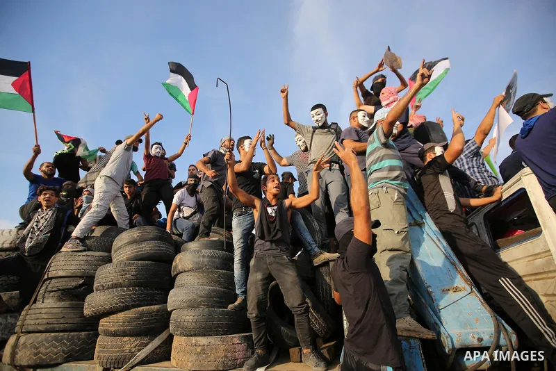 Palestinian protesters gather during clashes with Israeli troops in tents protest where Palestinians demand the right to return to their homeland at the Israel-Gaza border, in east of Gaza City on October 5, 2018. Photo...