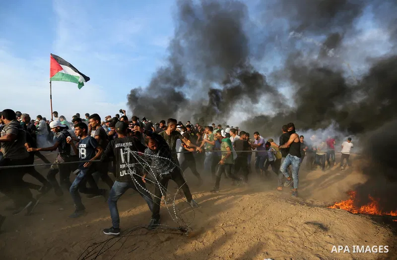 Palestinian protesters gather during clashes with Israeli troops in tents protest where Palestinians demand the right to return to their homeland at the Israel-Gaza border, in Khan Younis in the southern Gaza Strip on Oc...