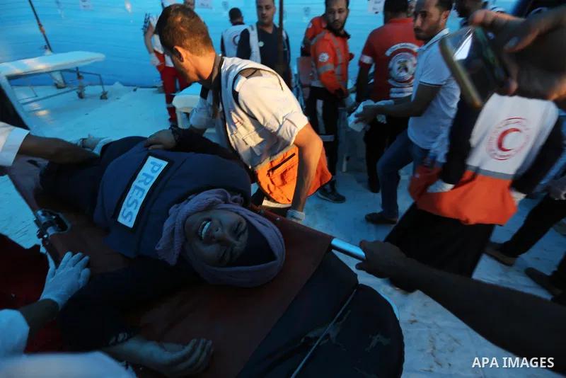 A Palestinian Journalist, Duaa Zo'rob receives treatment as he covering a demonstration where Palestinians demand the right to return to their homeland at the Israel-Gaza border, in Khan Younis in the southern Gaza Strip...