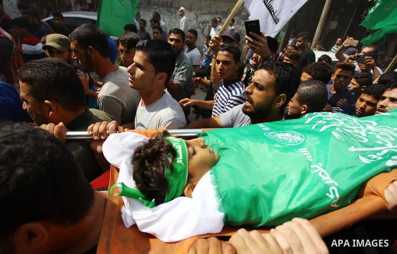 Mourners carry the body of Palestinian boy Faris al-Sersawi, 12, who was shot dead by Israeli froces during clashes in tents protest where Palestinians demand the right to return to their homeland at the Israel-Gaza bord...