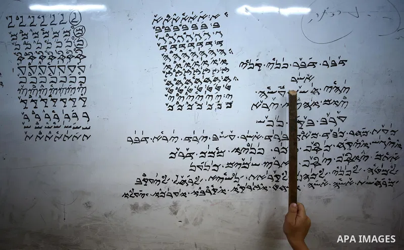 Samaritan tutor Ragheb Mfarrej ,78, teaches kids the ancient Samaritan language, at Mount Gerizim near the West Bank city of Nablus, on October 7, 2018. The kids start learning Hebrew ancient language on their 6 years ol...