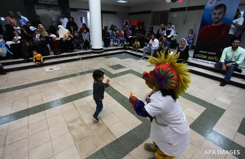 A Palestinian clown plays with children with cancer at el-Rantisi hospital in Gaza city, on October 7, 2018. Photo by Mahmoud Ajjour