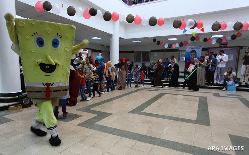 A Palestinian clown plays with children with cancer at el-Rantisi hospital in Gaza city, on October 7, 2018. Photo by Mahmoud Ajjour