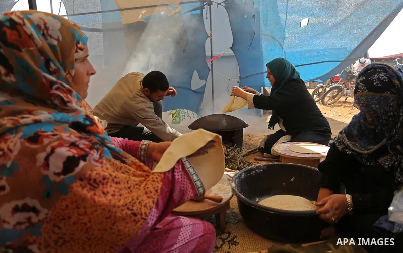 Palestinian women prepare traditional bread during a heritage festival at the Israel-Gaza border, in Khan Younis in the southern Gaza Strip on October 10, 2018. Photo by Ashraf Amra