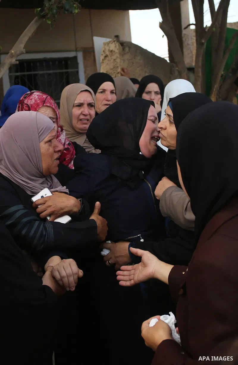 Palestinian relatives of Aisha al-Rabi, 48, weep during her funeral in the West Bank village of Becya, near The West Bank City of Salfit, 13 October 2018. According to media reports, al-Rabi was killed while her husband...
