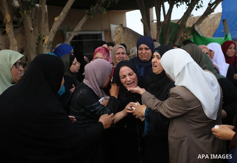 Palestinian relatives of Aisha al-Rabi, 48, weep during her funeral in the West Bank village of Becya, near The West Bank City of Salfit, 13 October 2018. According to media reports, al-Rabi was killed while her husband...
