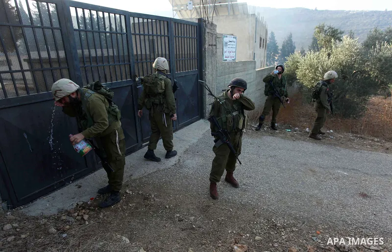 Israeli forces close the gate of a Palestinian school in the West Bank city of Nablus, on October 15, 2018. Photo by Shadi Jarar'ah