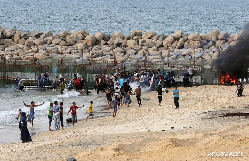 Palestinian protesters gather during clashes with Israeli forces in a demonstration against the Israeli blockade on Gaza Strip, along the Gaza sea barrier on the maritime border with Israel near Kibbutz Zikim, north of B...