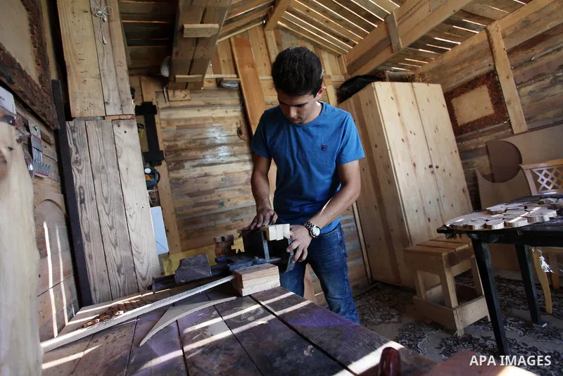 A Palestinian Nedal al-Nakhala, 20, works at a workshop "Antica Home", where he manufactures wooden products to sell it for customers, in Gaza City on October 16, 2018. Photo by Mahmoud Ajjour