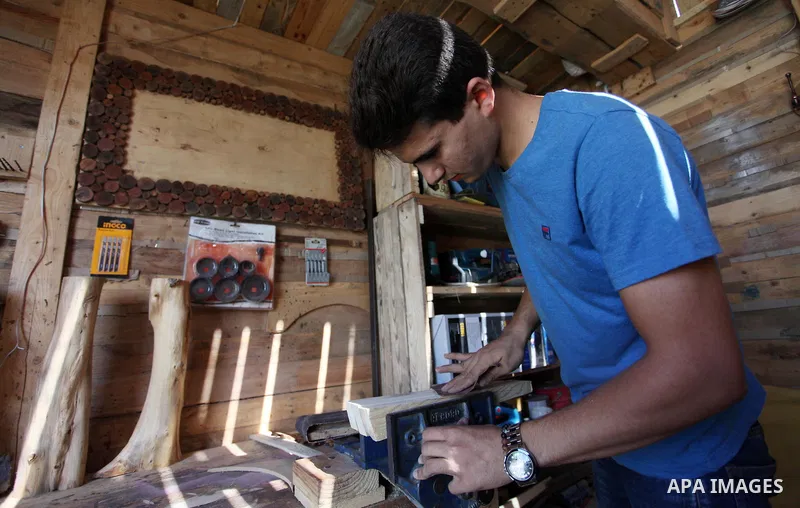 A Palestinian Nedal al-Nakhala, 20, works at a workshop "Antica Home", where he manufactures wooden products to sell it for customers, in Gaza City on October 16, 2018. Photo by Mahmoud Ajjour