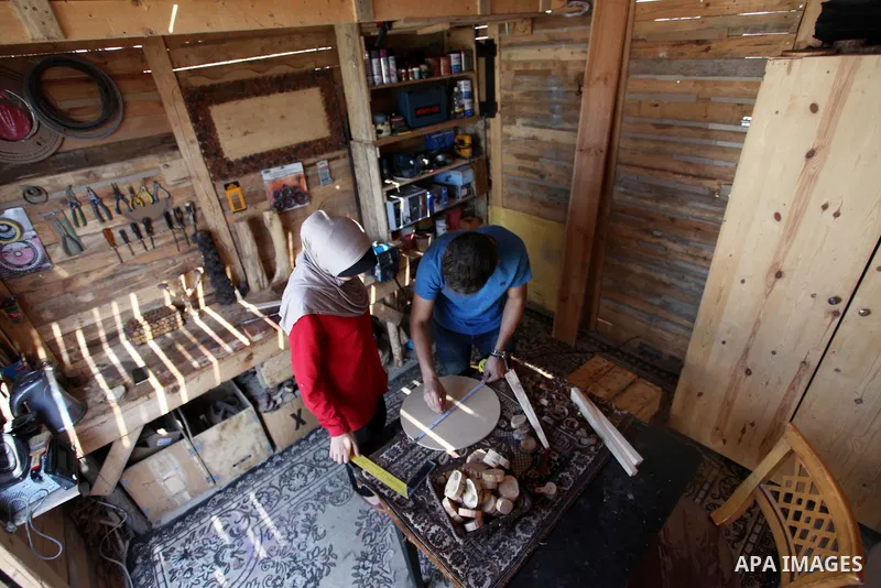 A Palestinian Nedal al-Nakhala, 20, and his sister Heba, 22, work at their workshop "Antica Home", where they manufacture wooden products to sell it for customers, in Gaza City on October 16, 2018. Photo by Mahmoud Ajjou...