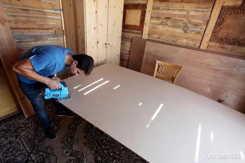 A Palestinian Nedal al-Nakhala, 20, works at a workshop "Antica Home", where he manufactures wooden products to sell it for customers, in Gaza City on October 16, 2018. Photo by Mahmoud Ajjour