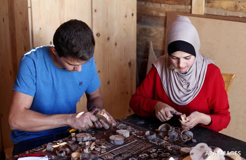 A Palestinian Nedal al-Nakhala, 20, and his sister Heba, 22, work at their workshop "Antica Home", where they manufacture wooden products to sell it for customers, in Gaza City on October 16, 2018. Photo by Mahmoud Ajjou...