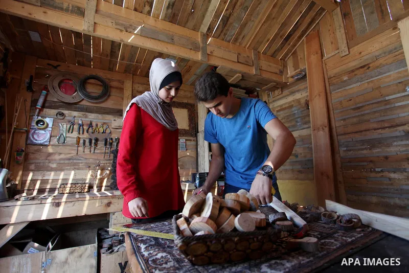 A Palestinian Nedal al-Nakhala, 20, and his sister Heba, 22, work at their workshop "Antica Home", where they manufacture wooden products to sell it for customers, in Gaza City on October 16, 2018. Photo by Mahmoud Ajjou...