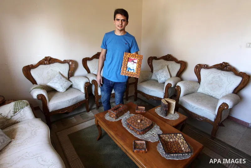 A Palestinian Nedal al-Nakhala, 20, displays wooden products which he was manufacture it with his sister Heba, 22, to sell it for customers, in Gaza City on October 16, 2018. Photo by Mahmoud Ajjour