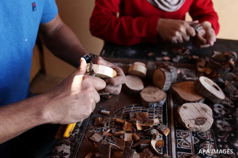 A Palestinian Nedal al-Nakhala, 20, and his sister Heba, 22, work at their workshop "Antica Home", where they manufacture wooden products to sell it for customers, in Gaza City on October 16, 2018. Photo by Mahmoud Ajjou...