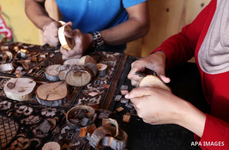 A Palestinian Nedal al-Nakhala, 20, and his sister Heba, 22, work at their workshop "Antica Home", where they manufacture wooden products to sell it for customers, in Gaza City on October 16, 2018. Photo by Mahmoud Ajjou...