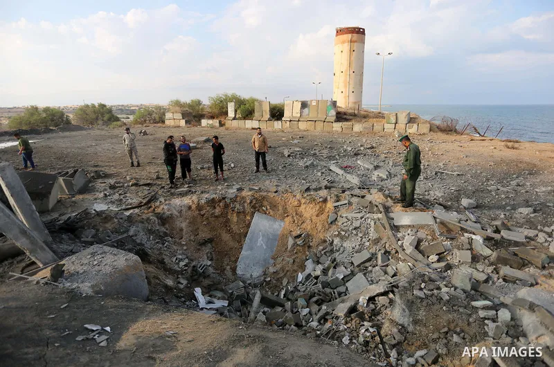 Palestinian men inspect the site targeted by an Israeli air strike, in Rafah in the southern Gaza strip on October 17, 2018. Photo by Ashraf Amra