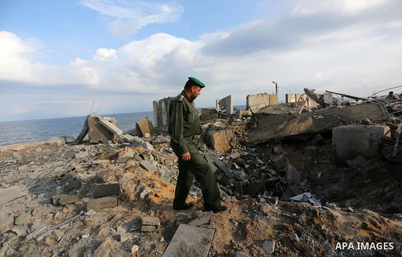 Palestinian men inspect the site targeted by an Israeli air strike, in Rafah in the southern Gaza strip on October 17, 2018. Photo by Ashraf Amra