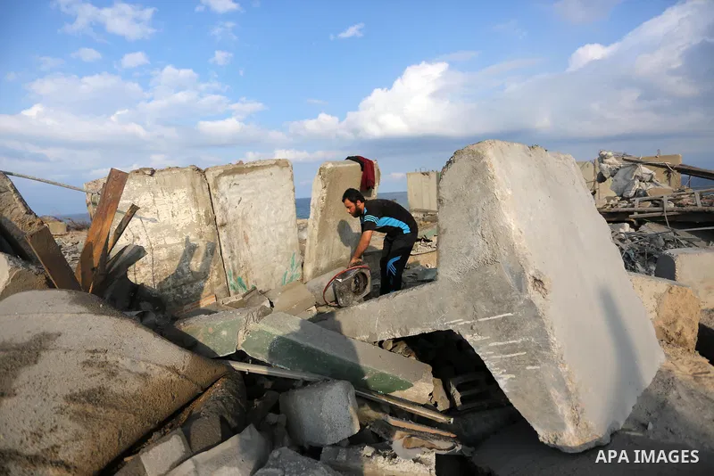 A Palestinian man inspects the site targeted by an Israeli air strike, in Rafah in the southern Gaza strip on October 17, 2018. Photo by Ashraf Amra