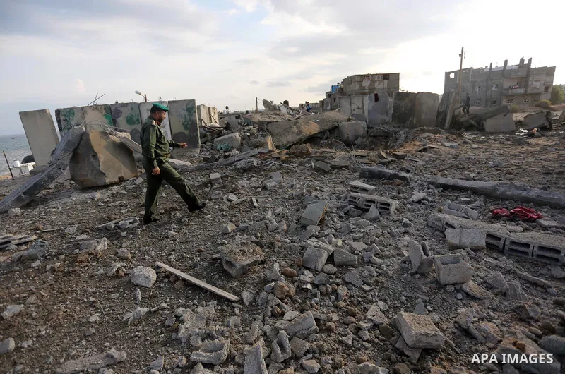 Palestinian men inspect the site targeted by an Israeli air strike, in Rafah in the southern Gaza strip on October 17, 2018. Photo by Ashraf Amra