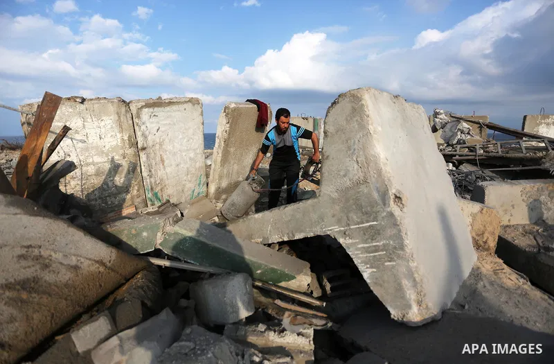 A Palestinian man inspects the site targeted by an Israeli air strike, in Rafah in the southern Gaza strip on October 17, 2018. Photo by Ashraf Amra