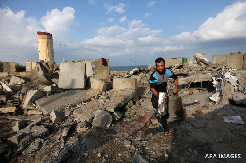 Palestinian men inspect the site targeted by an Israeli air strike, in Rafah in the southern Gaza strip on October 17, 2018. Photo by Ashraf Amra