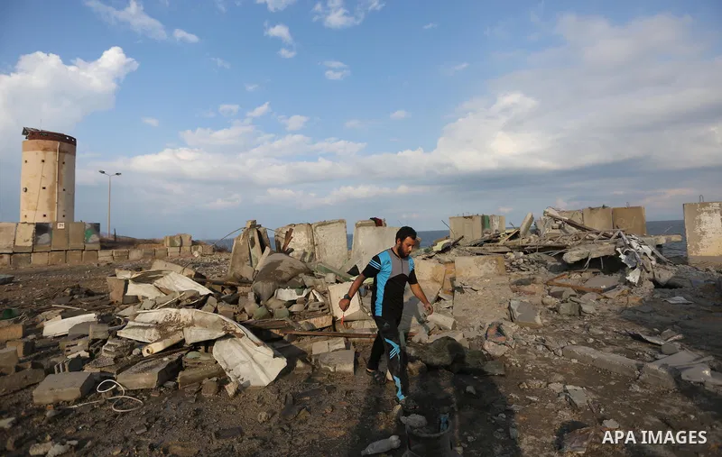 Palestinian men inspect the site targeted by an Israeli air strike, in Rafah in the southern Gaza strip on October 17, 2018. Photo by Ashraf Amra