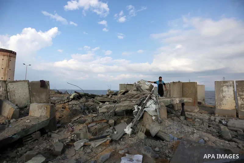 Palestinian men inspect the site targeted by an Israeli air strike, in Rafah in the southern Gaza strip on October 17, 2018. Photo by Ashraf Amra