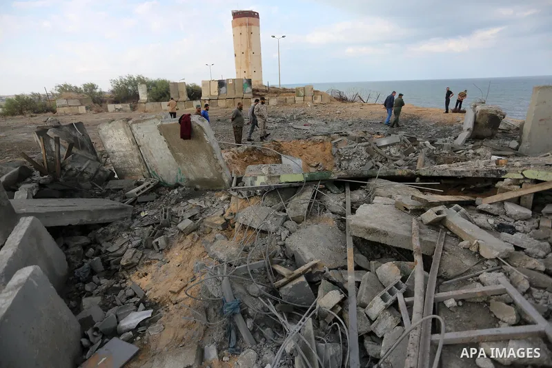 Palestinian men inspect the site targeted by an Israeli air strike, in Rafah in the southern Gaza strip on October 17, 2018. Photo by Ashraf Amra