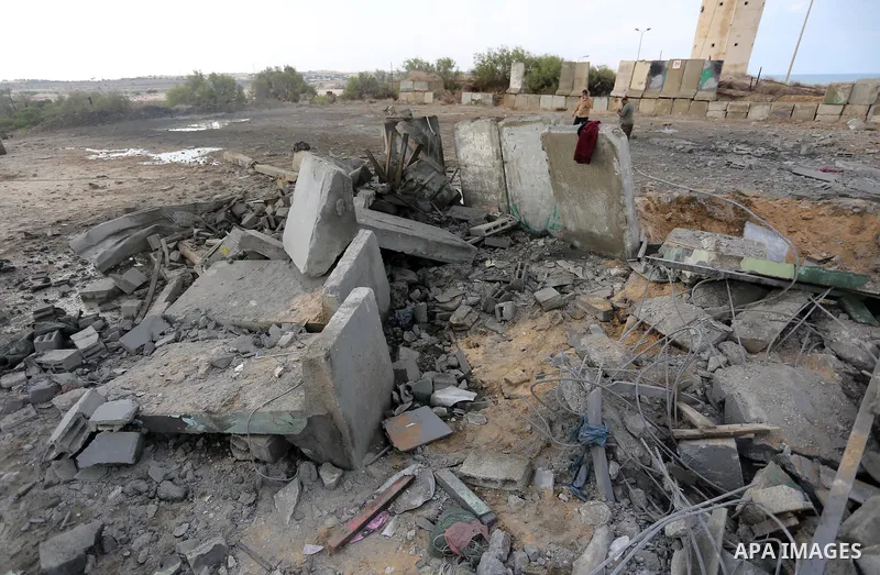 Palestinian men inspect the site targeted by an Israeli air strike, in Rafah in the southern Gaza strip on October 17, 2018. Photo by Ashraf Amra