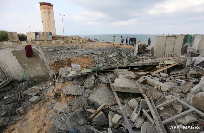 Palestinian men inspect the site targeted by an Israeli air strike, in Rafah in the southern Gaza strip on October 17, 2018. Photo by Ashraf Amra