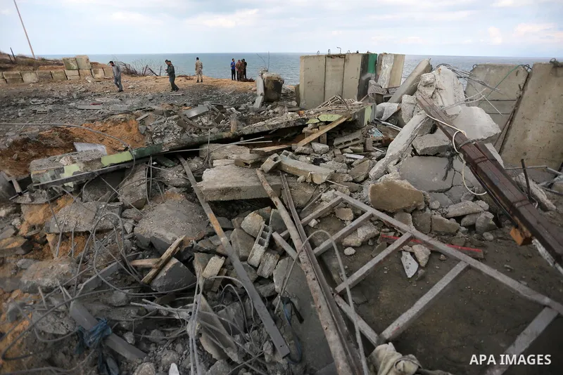 Palestinian men inspect the site targeted by an Israeli air strike, in Rafah in the southern Gaza strip on October 17, 2018. Photo by Ashraf Amra