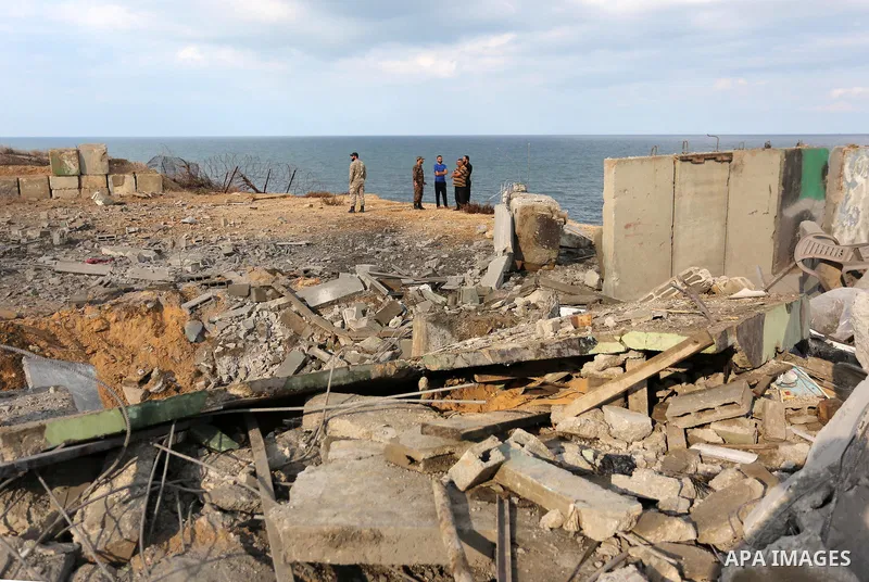 Palestinian men inspect the site targeted by an Israeli air strike, in Rafah in the southern Gaza strip on October 17, 2018. Photo by Ashraf Amra