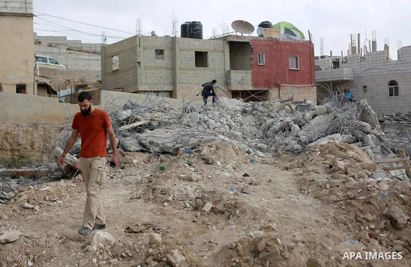 Palestinians stand on the rubble of their house that were demolished by the Israeli army, in the West Bank city Bireh, on October 18, 2018. The owners of the house said they were informed by the Israeli army that the dem...