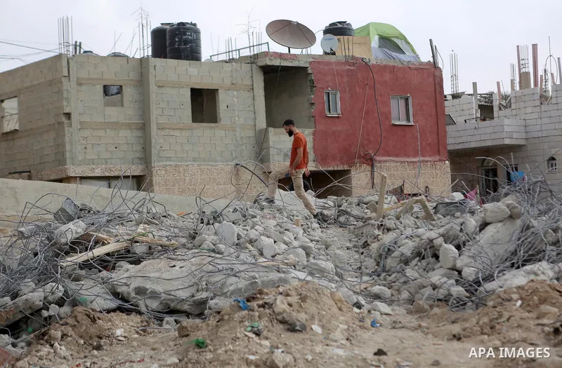 Palestinians stand on the rubble of their house that were demolished by the Israeli army, in the West Bank city Bireh, on October 18, 2018. The owners of the house said they were informed by the Israeli army that the dem...