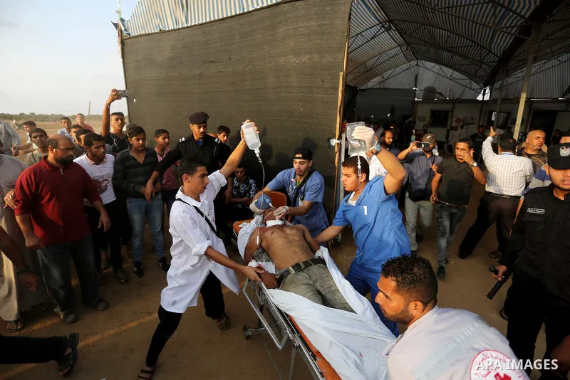 A Palestinian protester who was wounded during clashes with Israeli froces at the Israel-Gaza border, is carried on stretcher, in Khan Younis in the southern Gaza Strip on October 19, 2018. Photo by Ashraf Amra